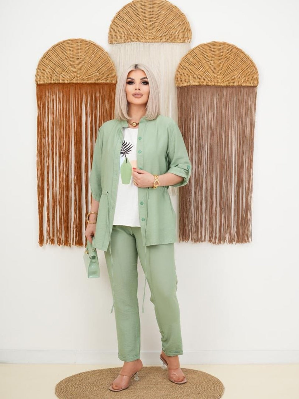 ქალის სამ ცალი კოსტიუმი, მსუბუქი და ელეგანტური. ქალბატონი მწვანე კოსტიუმით, დახვეწილი აქსესუარებით და ტრენდული დიზაინით.