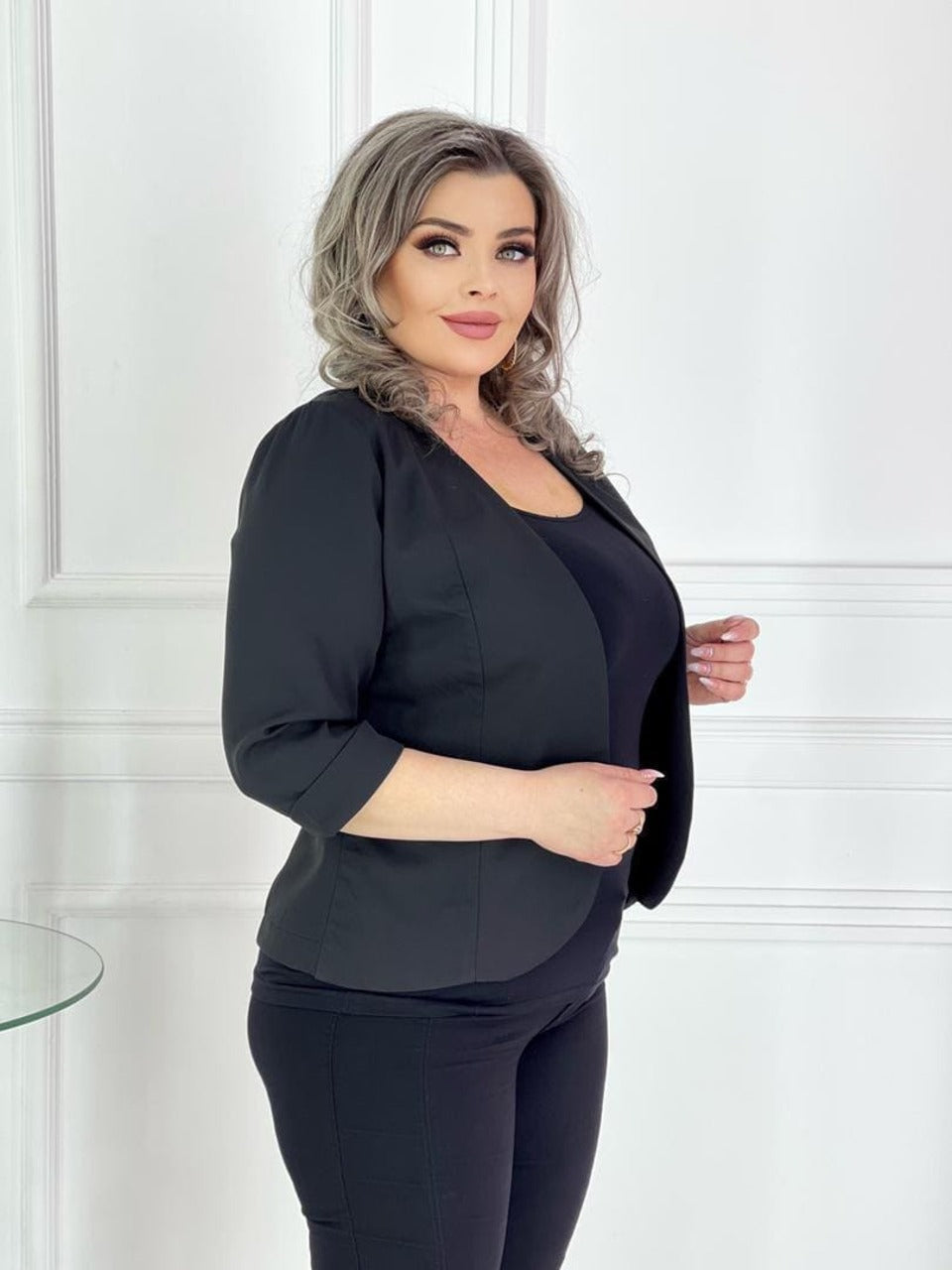 ქალით შავი კომფორტული პიჯაკი ქალებისთვის, რომელიც აცვია შავი ტანსაცმელი.