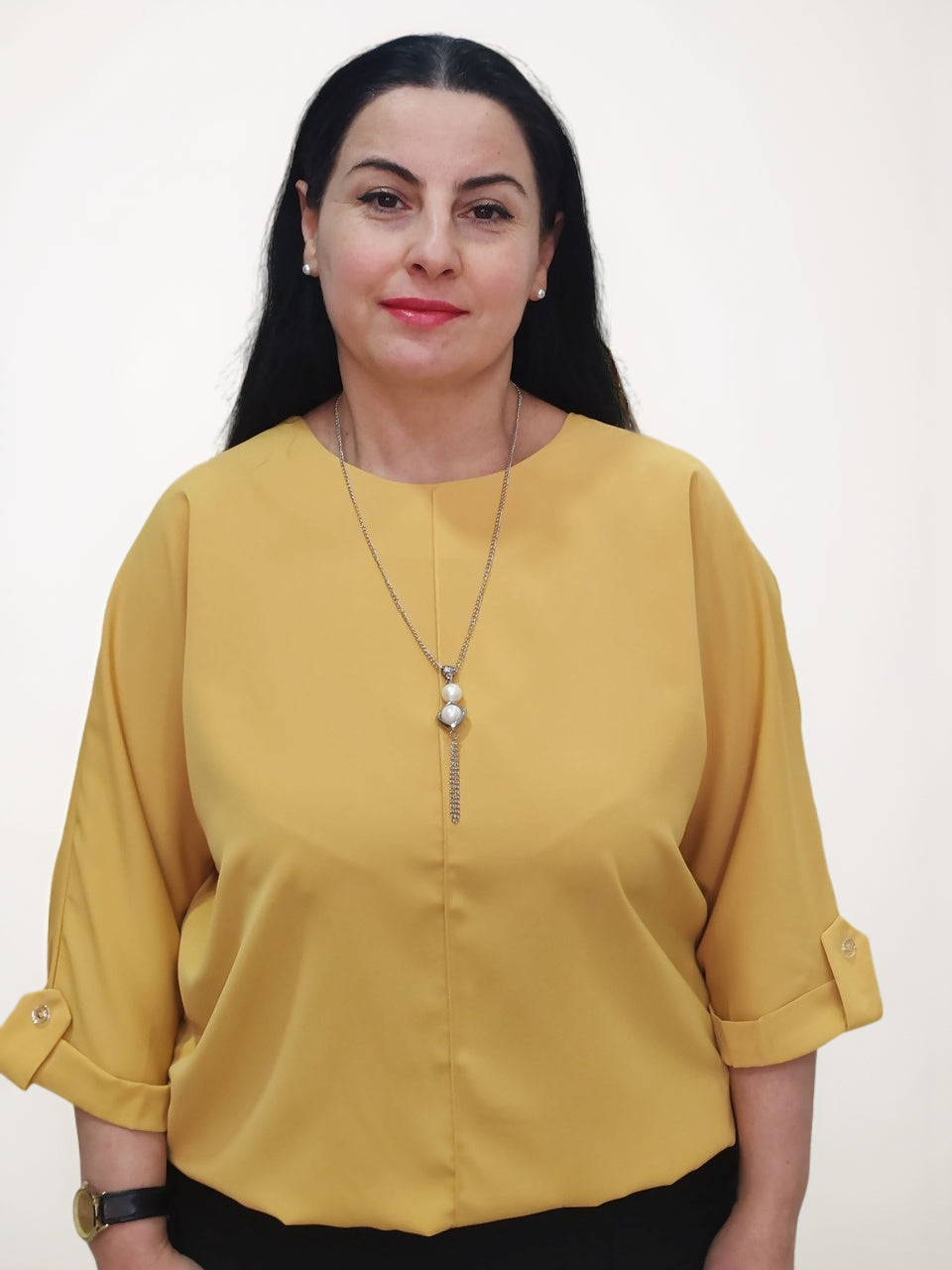 ქალის მოდელი წითელი პირჯვარი. ყვითელი ბლუზა და ლითონის მძივების ბლუზა.