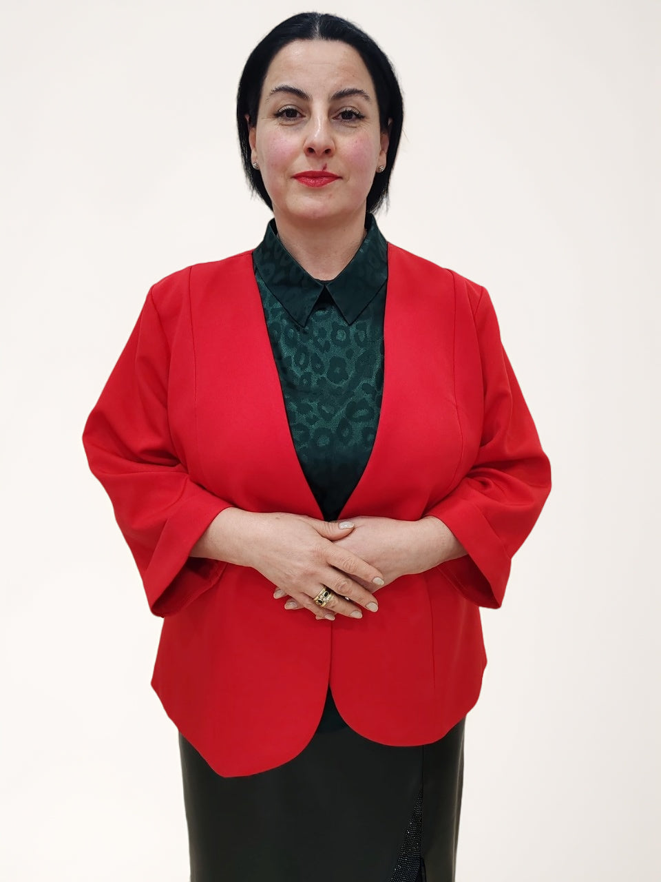ქალის წითელი პიჯაკი საქართველოში. ქალი დგას წინ, აცვია წითელი პიჯაკი და დედოფლის სტილის ყელი.