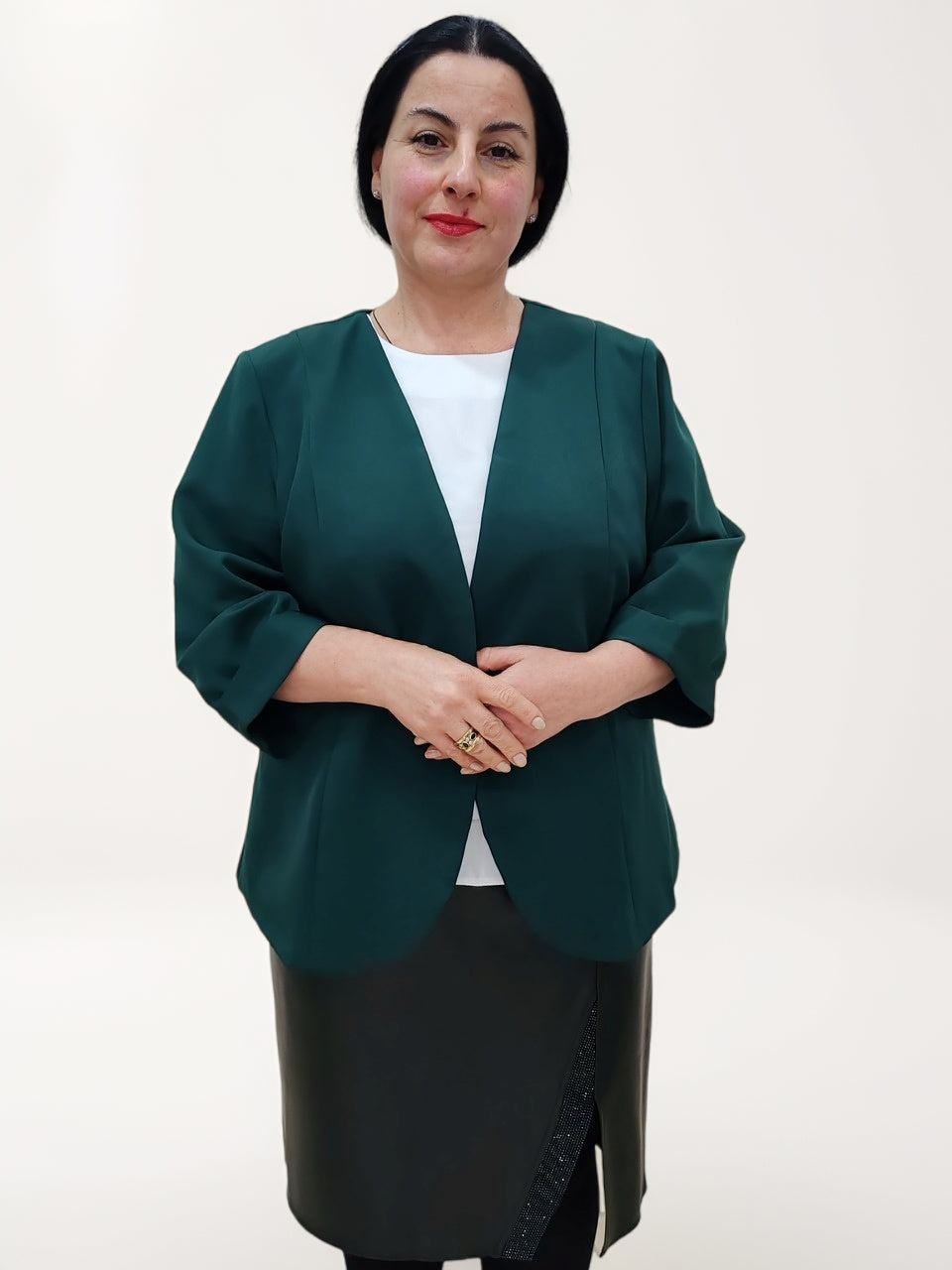 ქალის პიჯაკი პლუს ზომა, მოდელი აცვია მწვანე პიჯაკი და შავი ქვედაბოლო, შესანიშნავი არჩევანი ოფისისთვის.