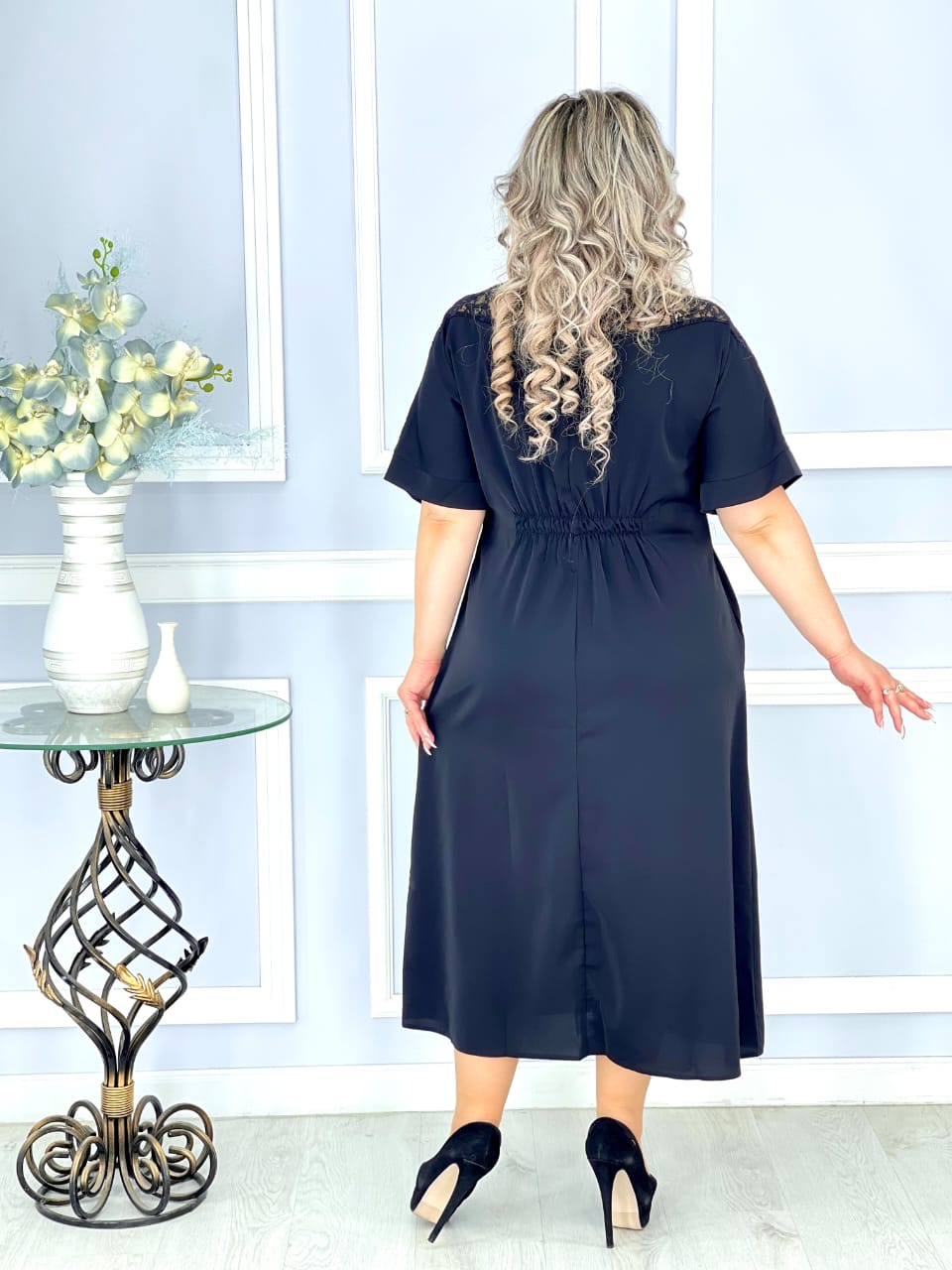 შავი აბრეშუმის კაბა მაქმანებით მორთული დეკოლტე საქართველოში. მოდელი უჩანს კაბას უკან, რაც ხაზგასმულია კაბის ელასტიური მჭიდრო ფორმით.