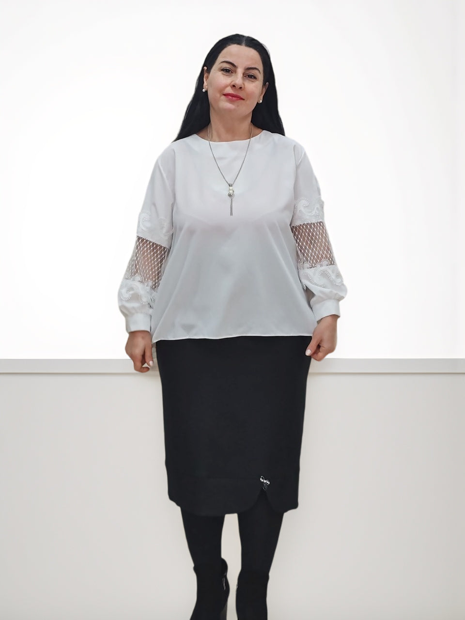 კომბინირებული outfit-ის მაგალითი, სადაცკლასიკური ქვედაბოლო წინ ოვალური ჭრილით შავი ფერის, ერთმანეთს მჭიდროდაა შერწყმული თეთრი ზედასთან.