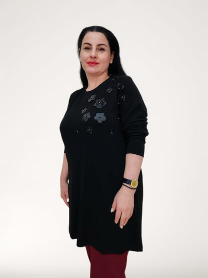 ბლუზა, ეკო ტყავის ყვავილებით და მძივებით მორთული შავი ბლუზა, მოდელი შავი ბლუზით იზოლირებულ ფონზე.