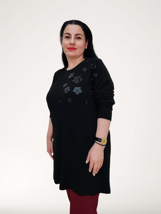 ბლუზა, ეკო ტყავის ყვავილებით და მძივებით მორთული შავი ბლუზა, მოდელი შავი ბლუზით იზოლირებულ ფონზე.