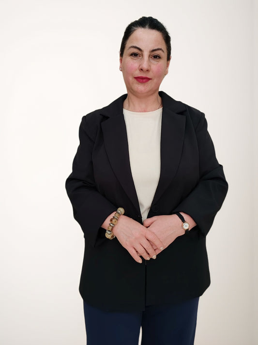 ქალის პიჯაკი კლასიკური შავი თბილისის მოდელი, რომელსაც აცვია პირი, პროფესიონალური ხედით.