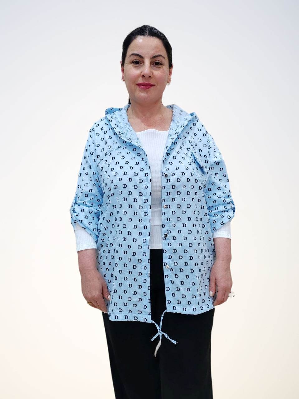 Блузка - ბამბის ბლუზა თავსახურით,light blue design with D letter pattern, model presenting the front view.
